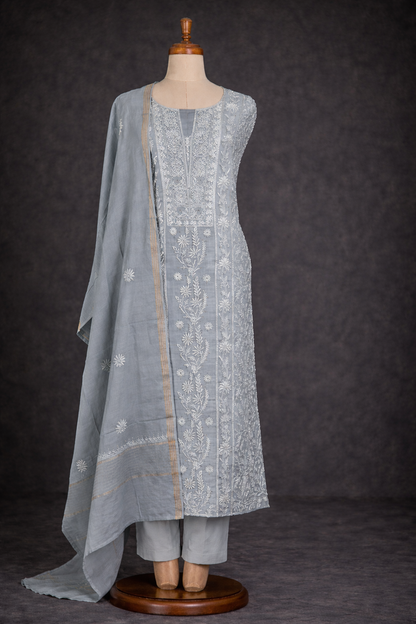 Lucknowi Chikankari unstitched suit in soft grey with intricate hand embroidery and elegant drape.