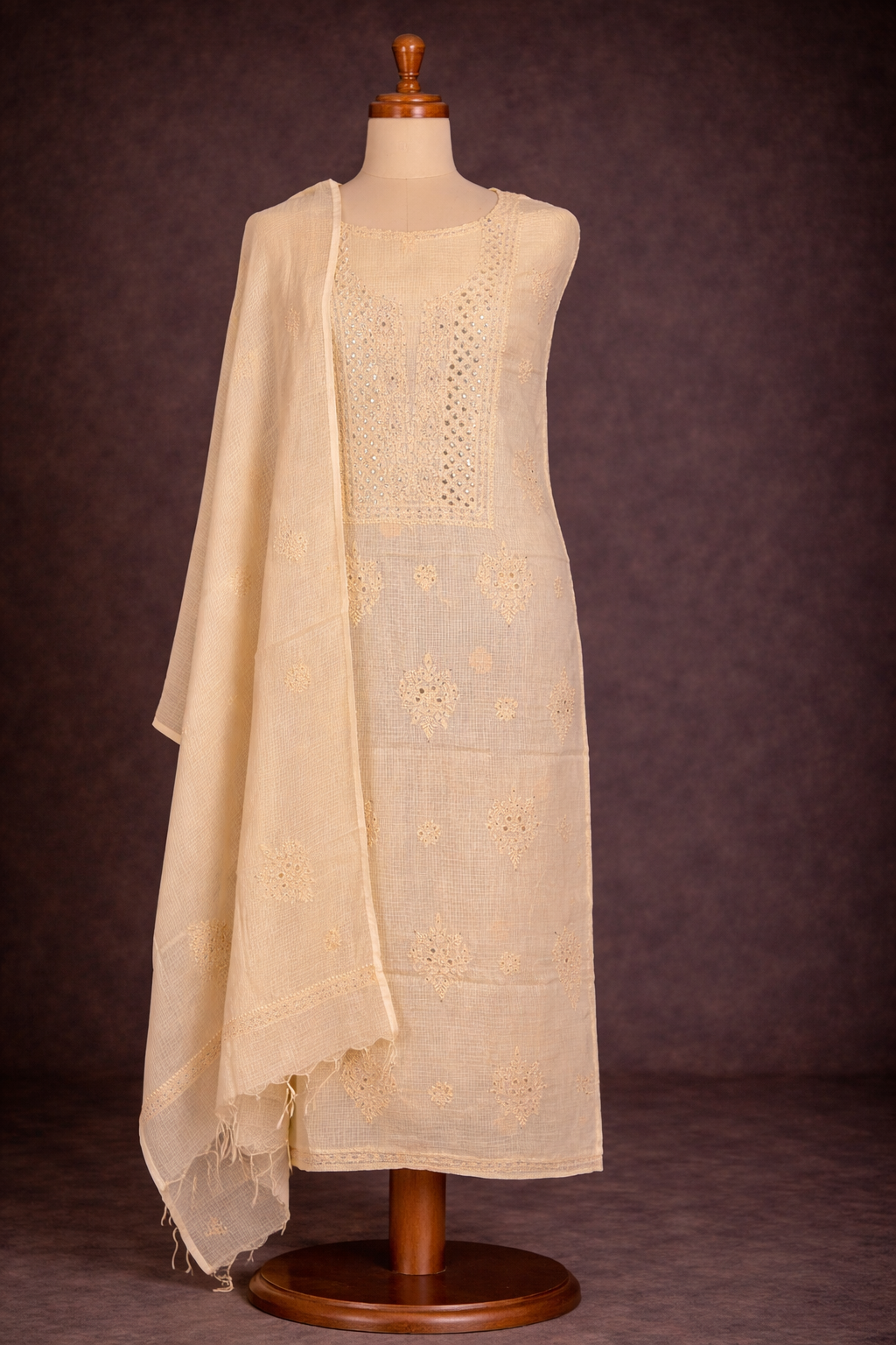 Lucknowi chikankari unstitched suit in dusky yellow with Badla work, elegant cotton fabric, displayed on a dress form.