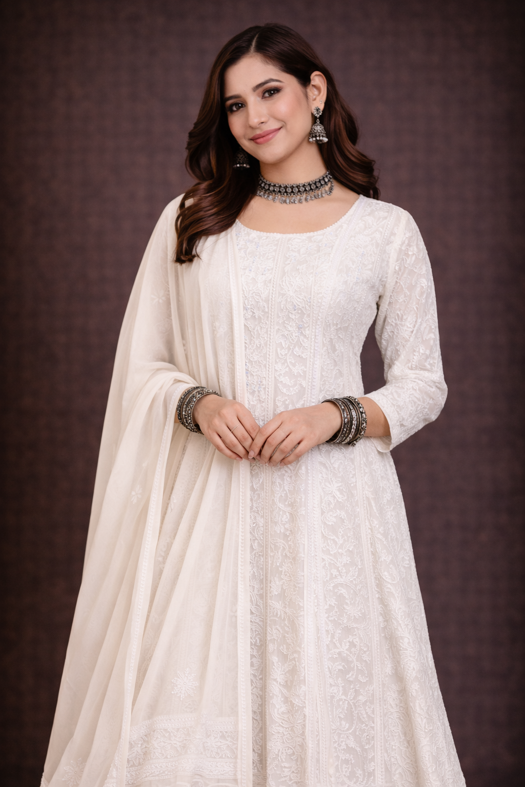 Lucknowi Chikankari Anarkali suit worn by a woman, showcasing intricate embroidery and elegant white fabric.